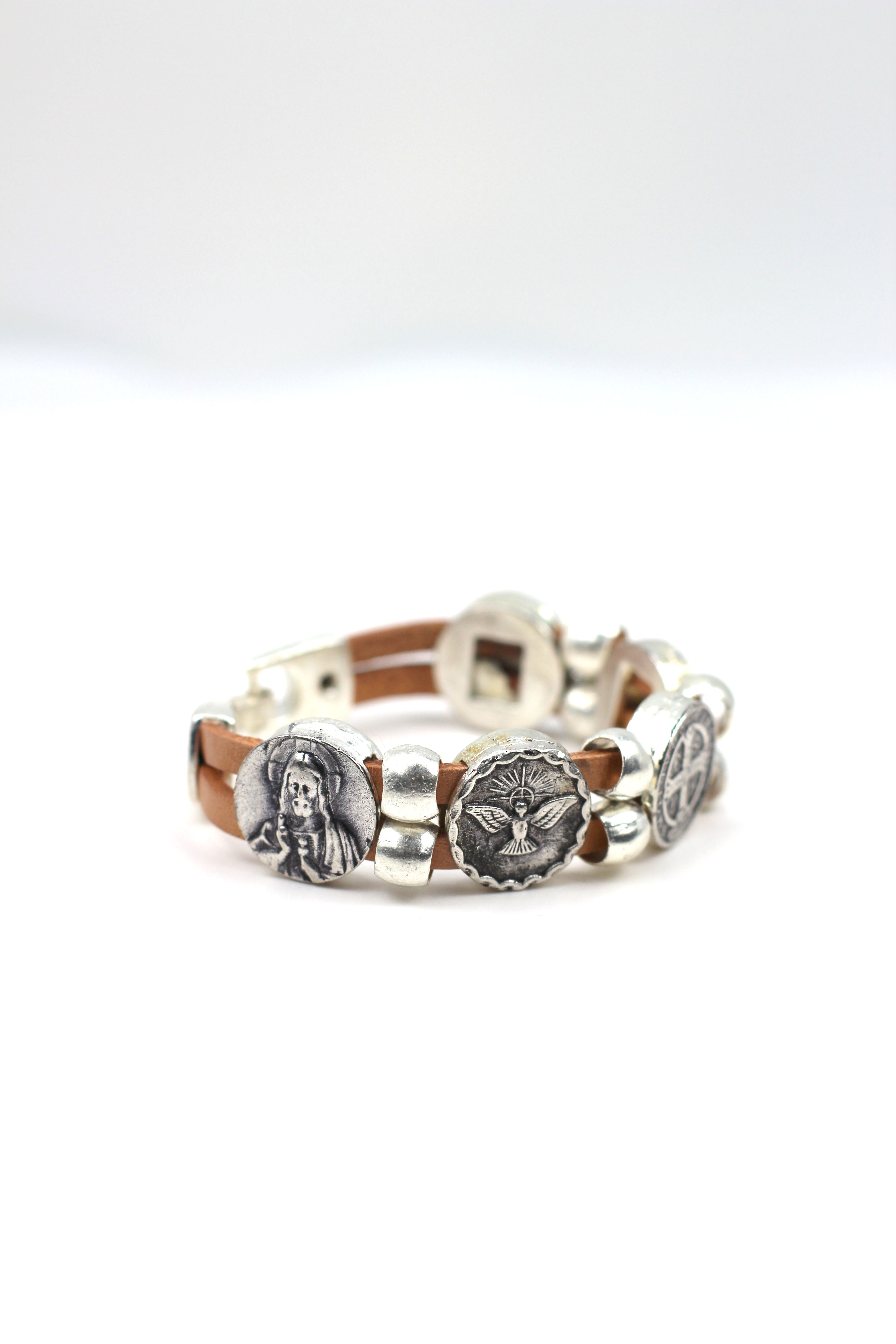 Pulsera Vintage con Doble Correa de Cuero y Medallas de La Virgen María, San Benito, Sagrado Corazón de Jesús, Ángel de la Guarda y Espíritu Santo joyería artesanal de Graciela's Collection