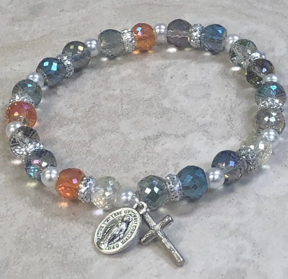 Pulsera de rosario con cuentas brillantes y cristales de strass. Medalla milagrosa y crucifijo.