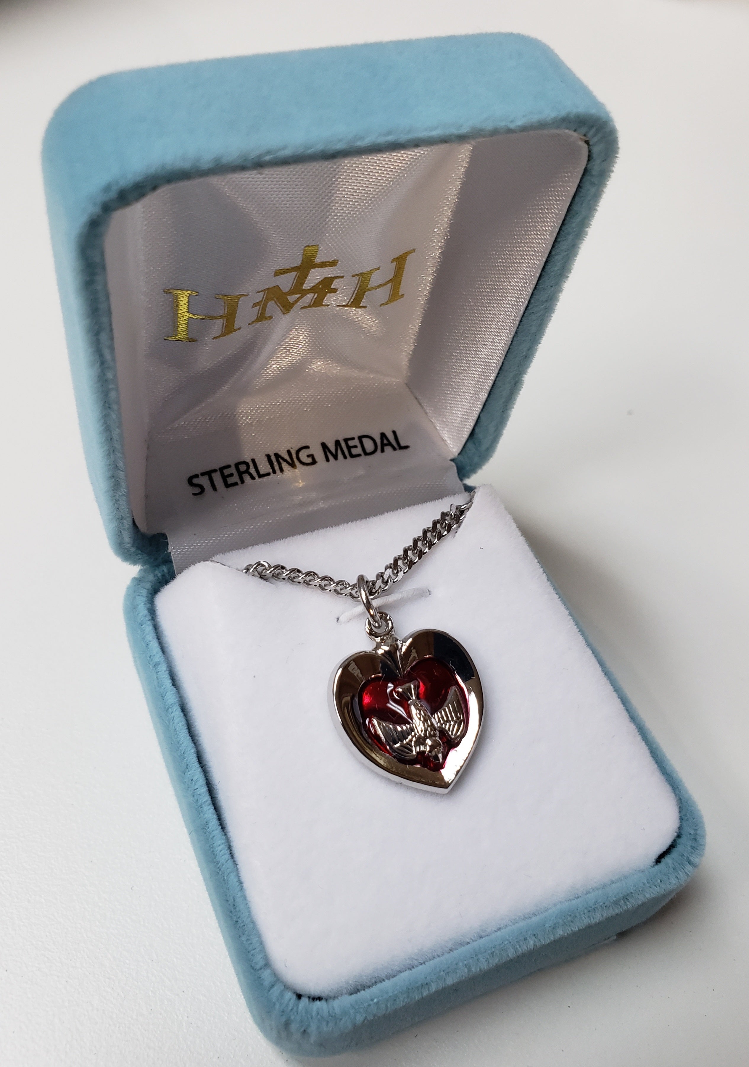 Corazón con incrustaciones del Espíritu Santo bañado en rodio genuino y muy pulido en plata esterlina