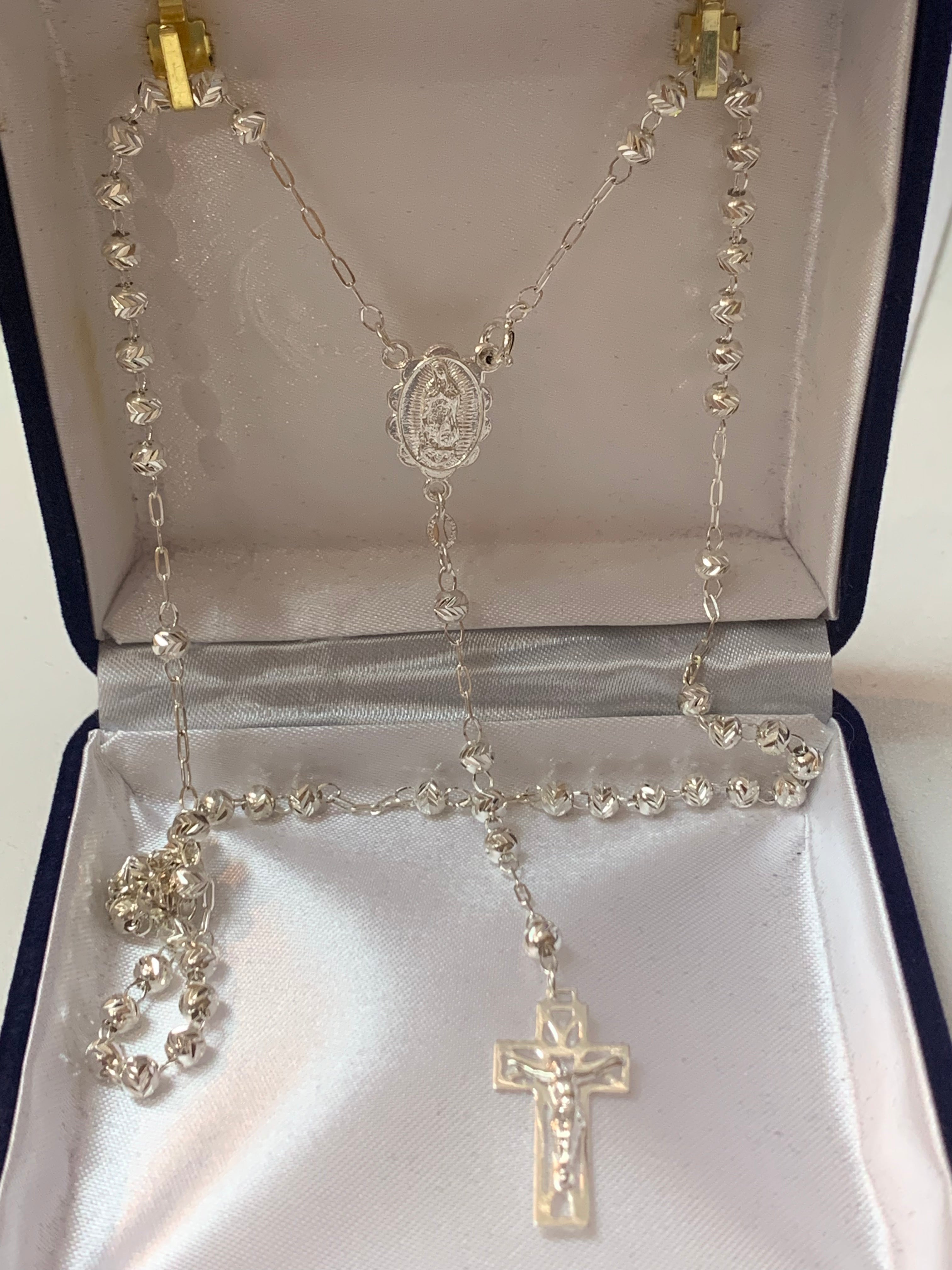Rosario de plata con medalla de San Benito o Nuestra Señora de Guadalupe en el centro