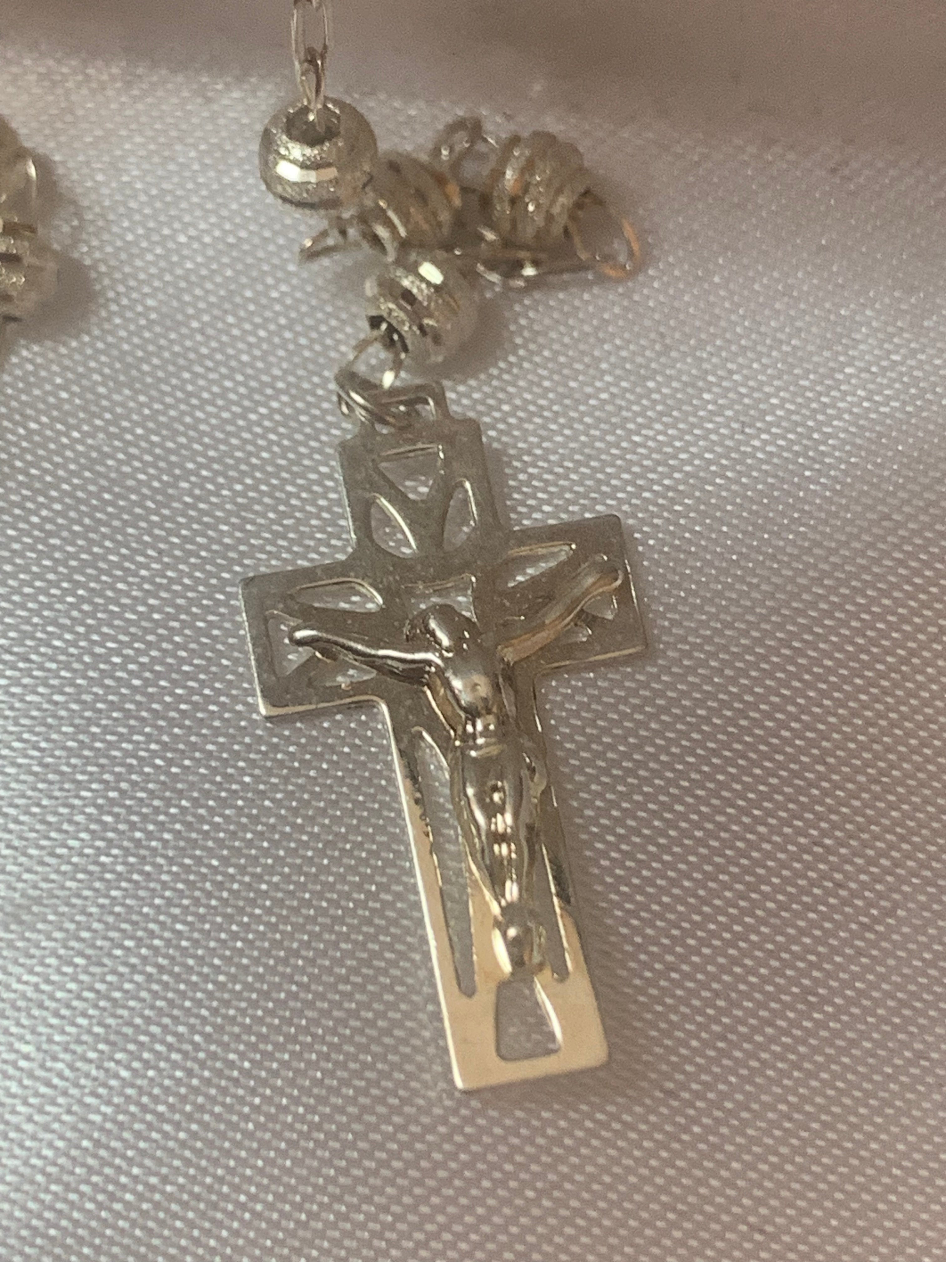 Rosario de plata con medalla de San Benito o Nuestra Señora de Guadalupe en el centro