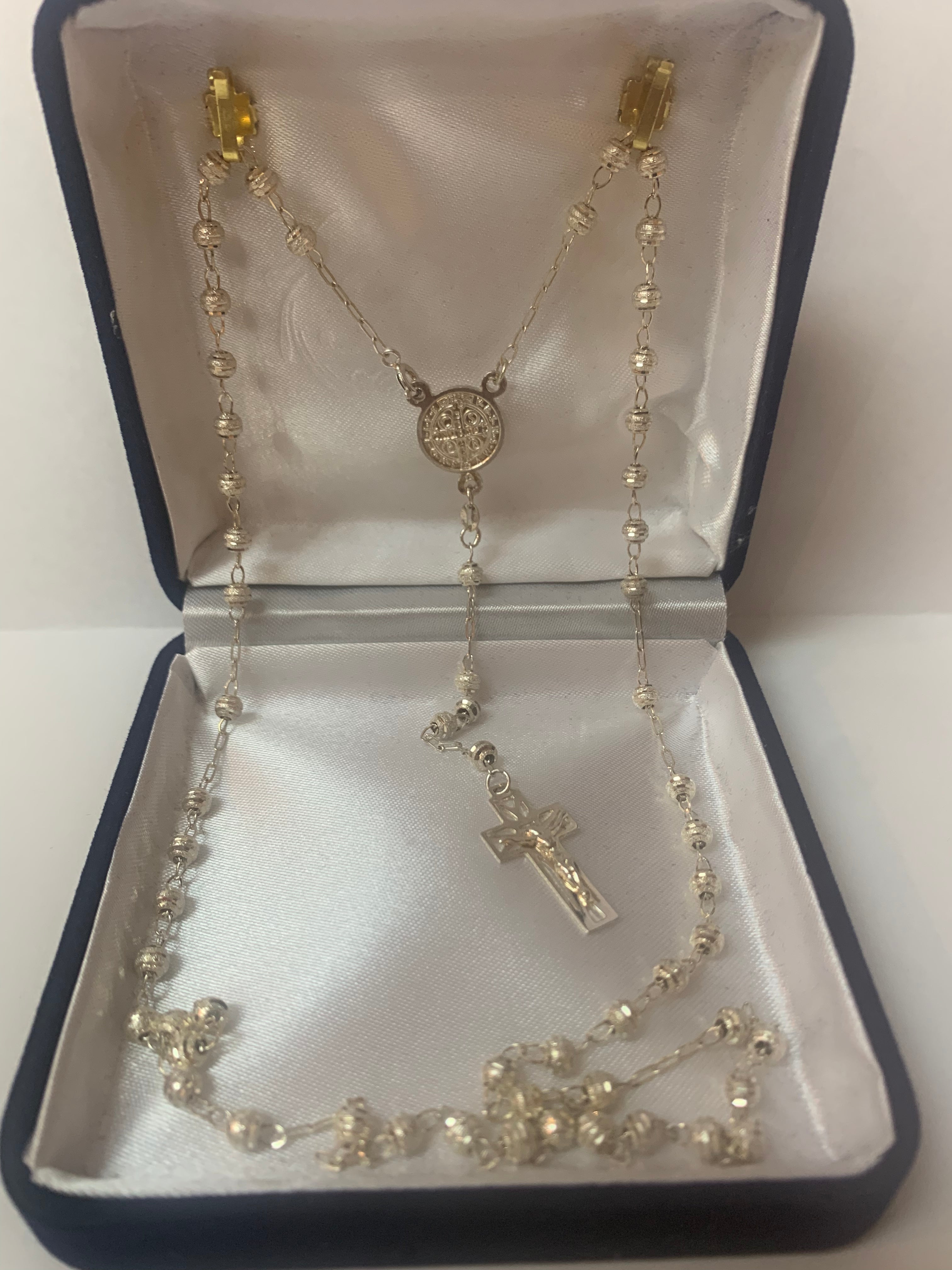 Rosario de plata con medalla de San Benito o Nuestra Señora de Guadalupe en el centro